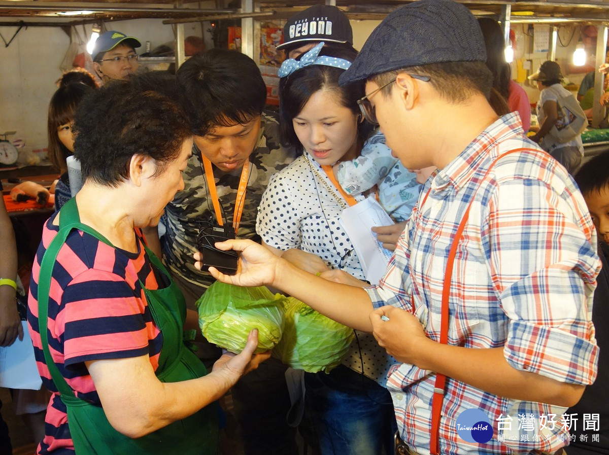 幸美蔬菜攤老闆娘在市場料理達人的導覽活動中與民眾說明挑選蔬菜的秘訣