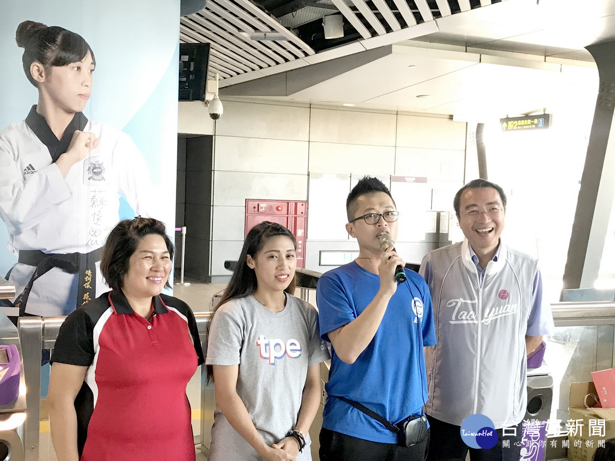 桃捷A18站設置世大運得牌選手形象照,跆拳道品勢混合團體項目金牌得主蘇佳恩與母親王仙蓮、啟蒙教練黃任宏和桃園董事長劉坤億合影。