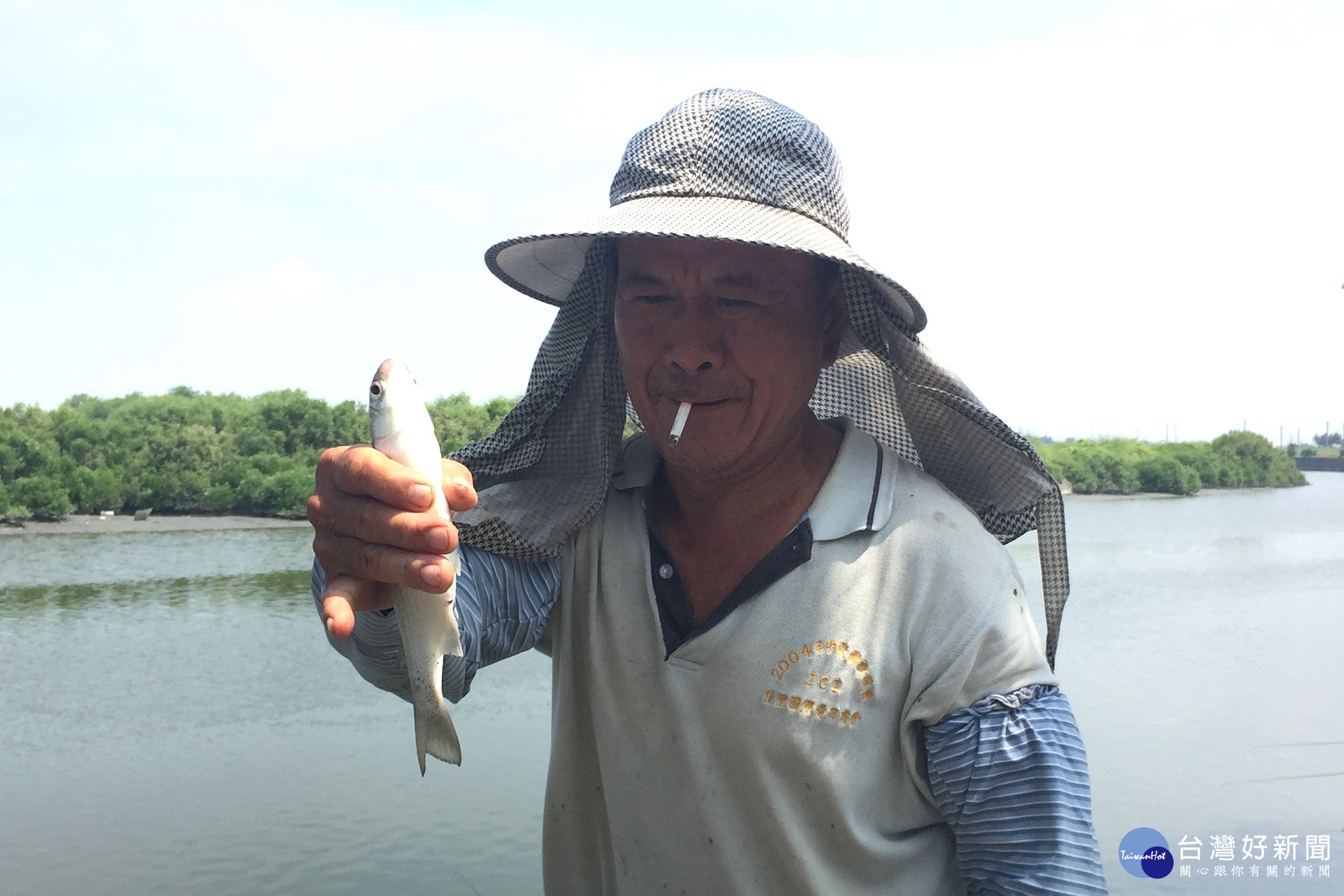 釣友拿起剛上鉤的豆仔魚說，長的肥滋滋，營養又好吃。(圖/記者黃芳祿攝)