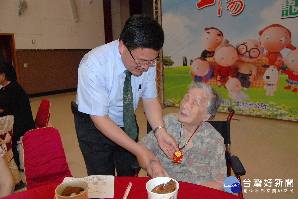 彰化市長邱建富為百歲人瑞陳王不碟掛上金鎖片。