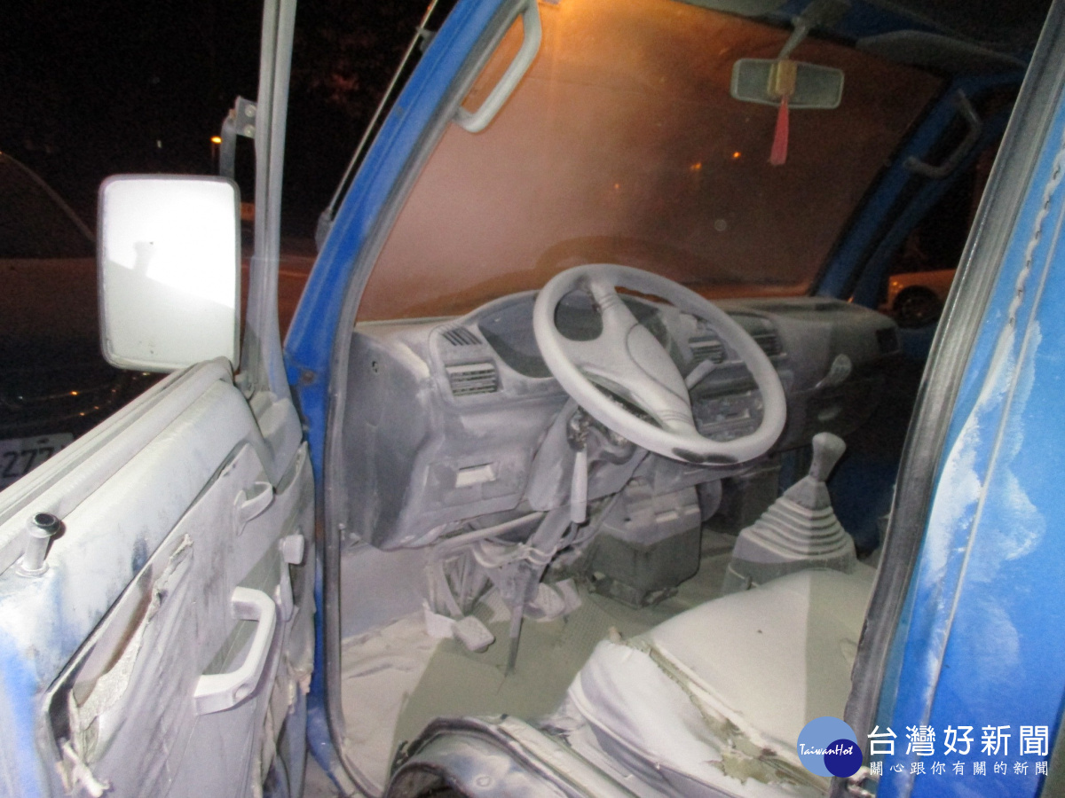 警員吳瑞橋壓低身子協助楊男查看小貨車的電瓶,檢視是否有鬆脫之處。