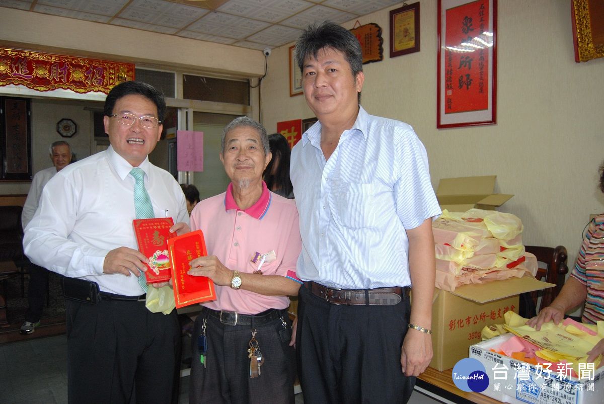 彰化市長邱建富在南瑤里辦公處發放重陽敬老禮金與麵線給長輩。