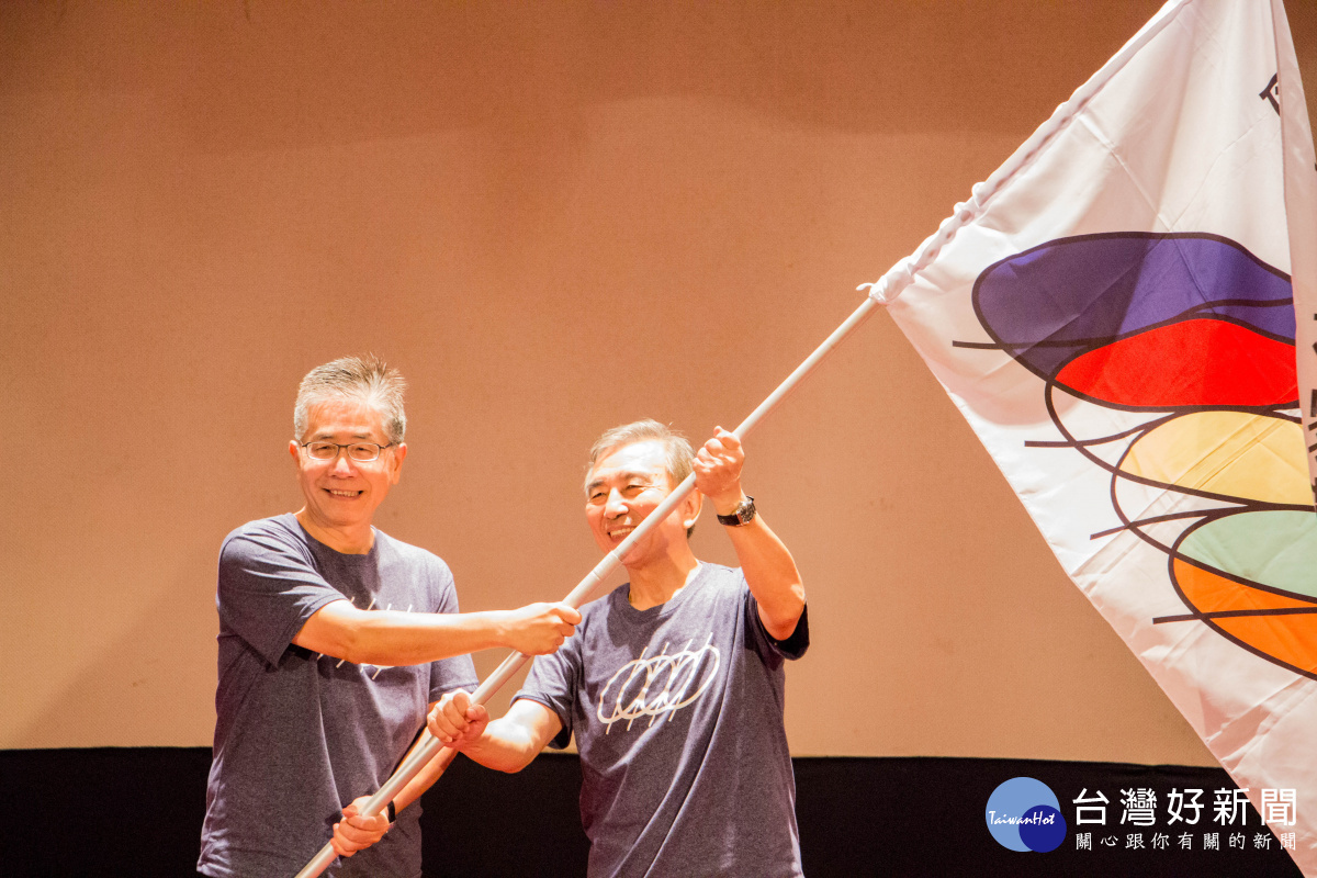 中央大學周景揚校長(左)交接會旗給下一屆主辦學校中央警察大學刁建生校長(右)。