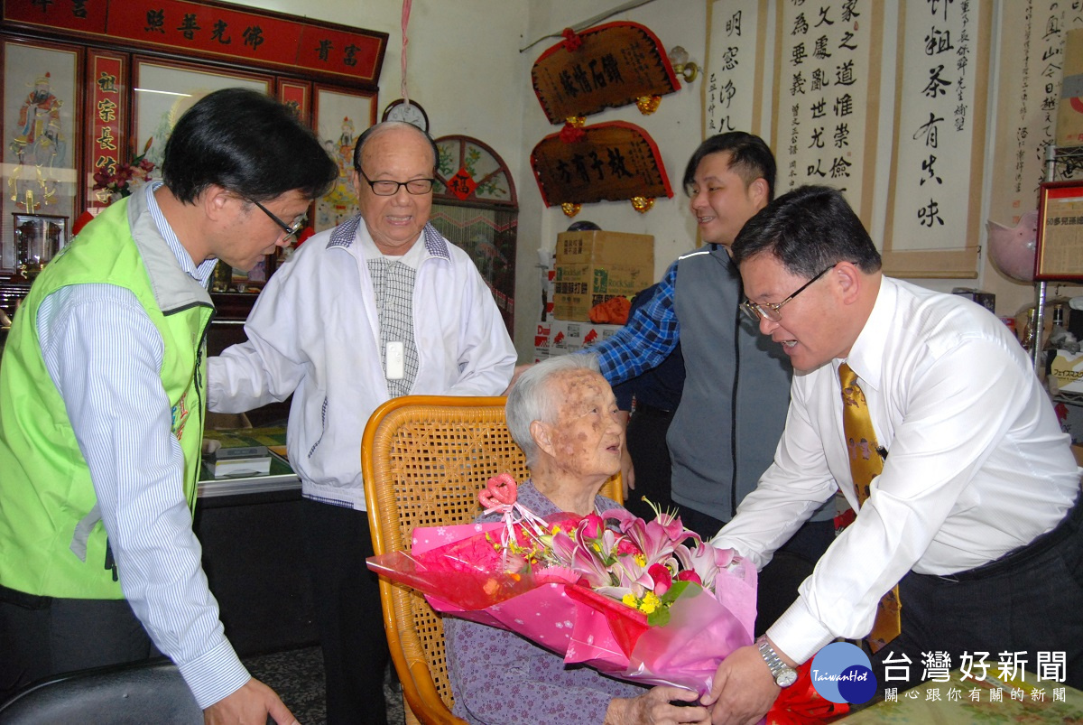 彰化市長邱建富為長住彰化市全縣最年長的梁李險阿嬤獻花。