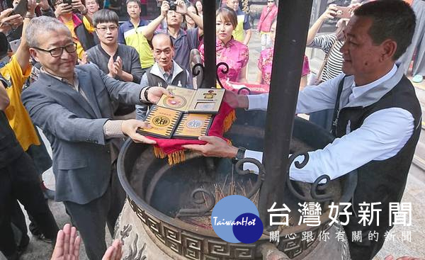 「虎爺悠遊卡」套組還含有一枚1元文創發財金,經香爐過火儀式加持,希望信眾順風又發財。(記者陳昭宗拍攝)
