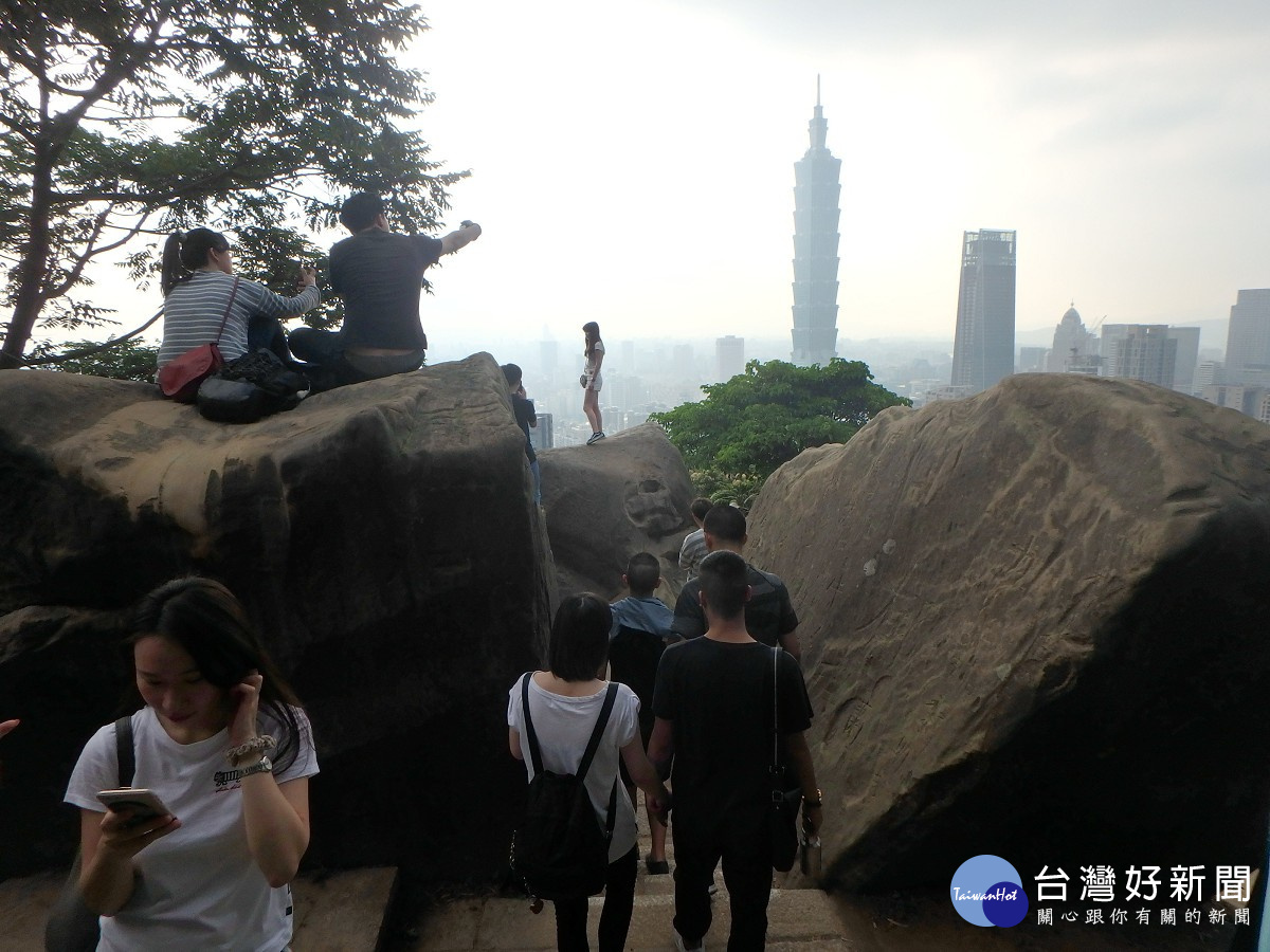 民眾坐在六巨石上欣賞美麗的台北盆地。（圖／大地處提供）