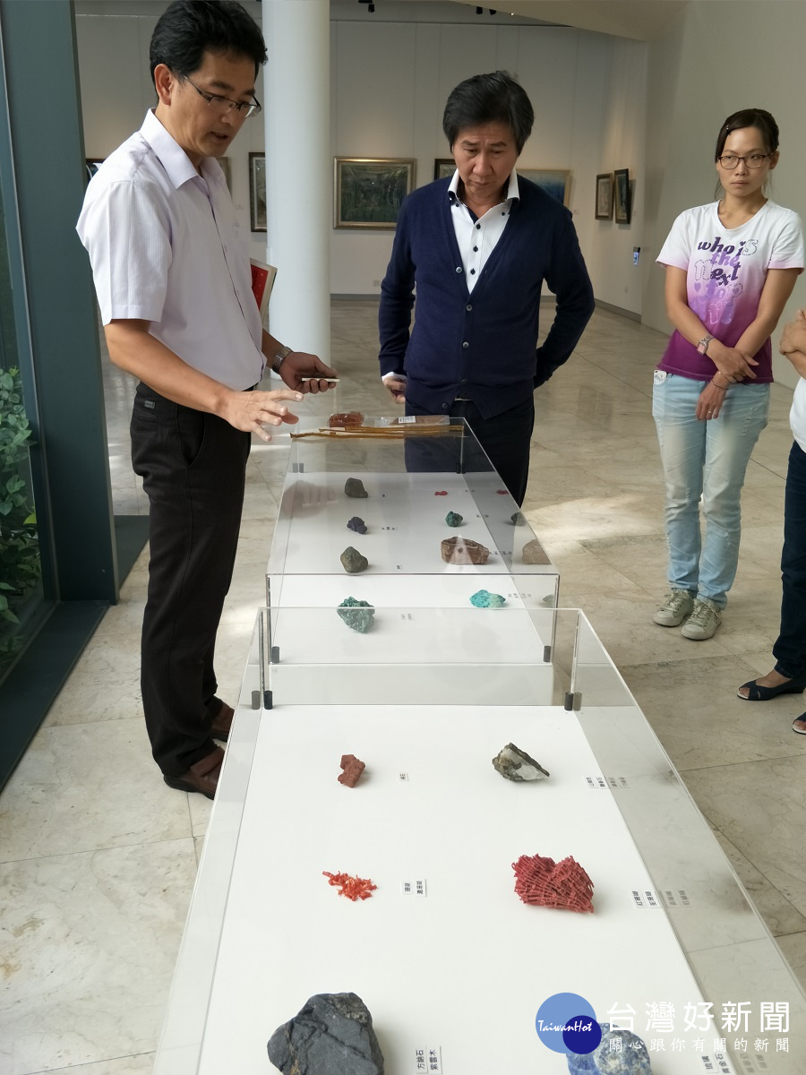 第35屆台灣膠彩畫展現場,由林必強理事長說明介紹膠彩畫的原礦石(右為文化局長陳文彬)。圖/記者鄧富珍攝