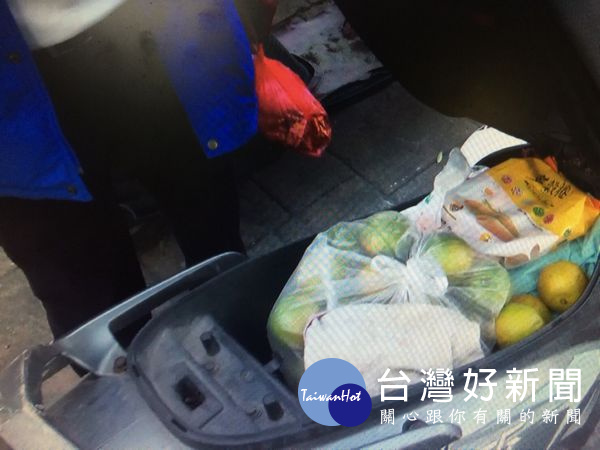 竊賊路過發現他人車上有一袋水果,貪小便宜將水果藏在自己的機車置物箱內。(記者陳昭宗拍攝)