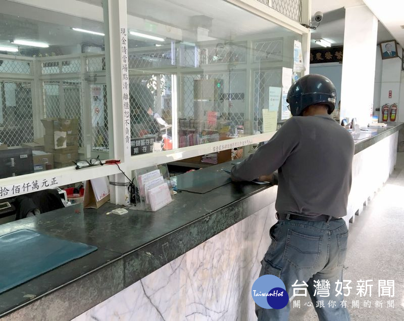 頭戴安全帽的歹徒持槍進入口湖鄉農會信用部搶奪現金，歹徒控制現場喝令行員不許動。（記者陳昭宗拍攝）