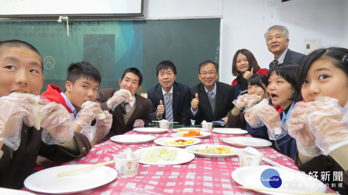 六和高中教日本學生包潤餅與林繼生校長(後排右三)一起品嚐美食。