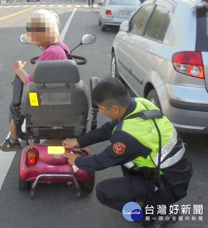 警方貼心為長輩騎乘之電動車黏貼反光警示紙，提高能見度保障行車安全，長輩們直說「揪感心ㄟ」。（記者陳昭宗拍攝）