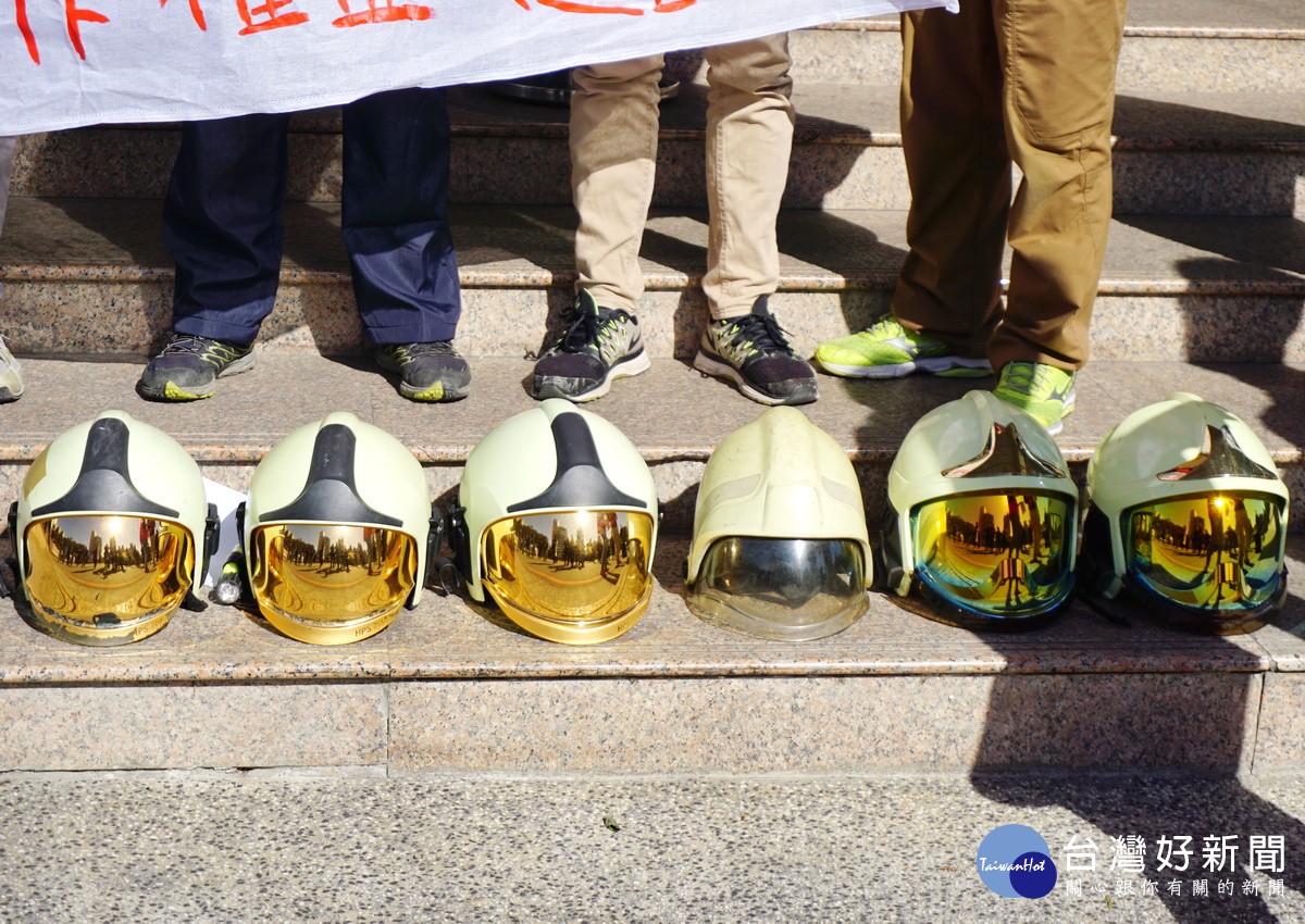 屋大火殉職警消家屬及「消防員工作權益促進會」人員在桃園市政府前擺出6消防人員頭盔,向桃園市政府陳情並提出3點訴求。