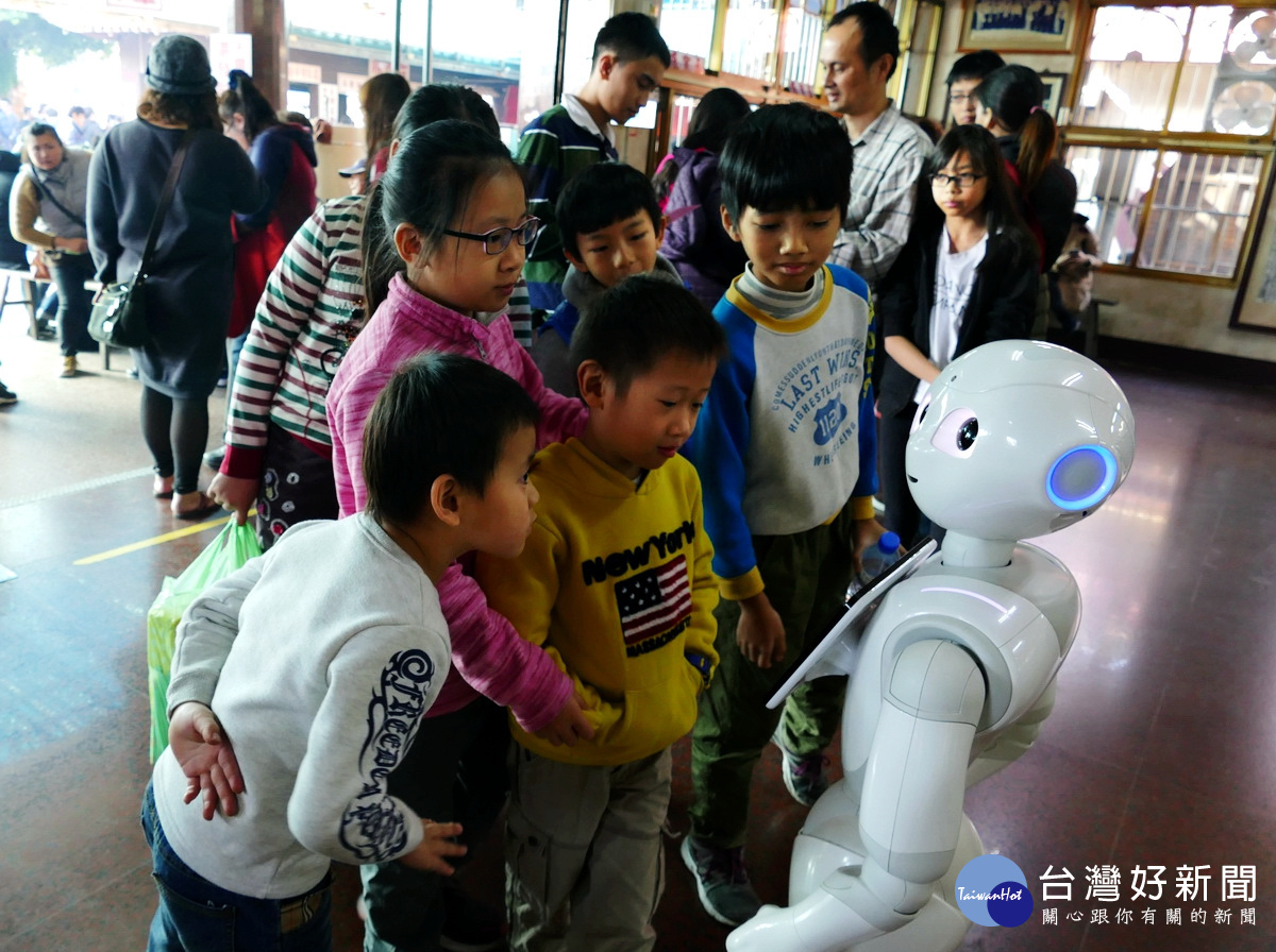 大人回紫南宮還金，小孩開心與紫南宮聘雇的Pepper智慧機器人「阿福」互動。