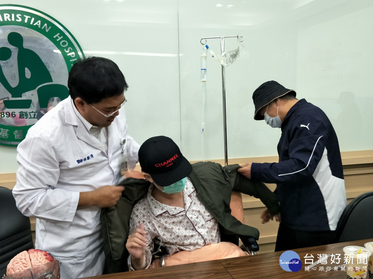 彰基中風暨神經加護病房主任邱駿清醫師為病患小偉穿上外套保暖。圖/記者鄧富珍攝