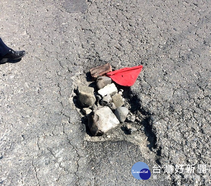 水林所員警發現沿途坑洞不少，讓來往車輛行駛經過時險象環生，於是緊急叫來機具將坑洞填補。（記者陳昭宗拍攝）