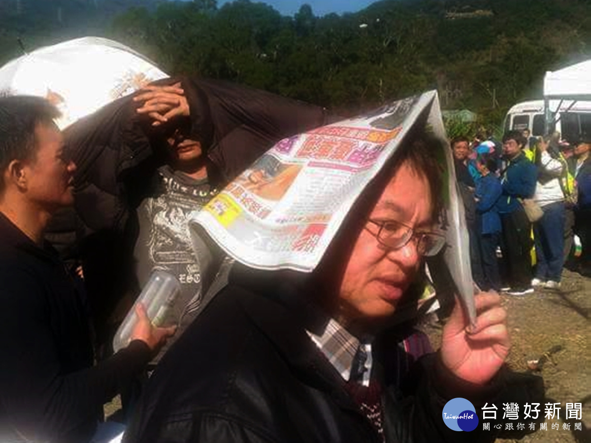 由於陽光直射過於強烈,不少人找不到遮陽傘,乾脆用報紙或衣服遮陽