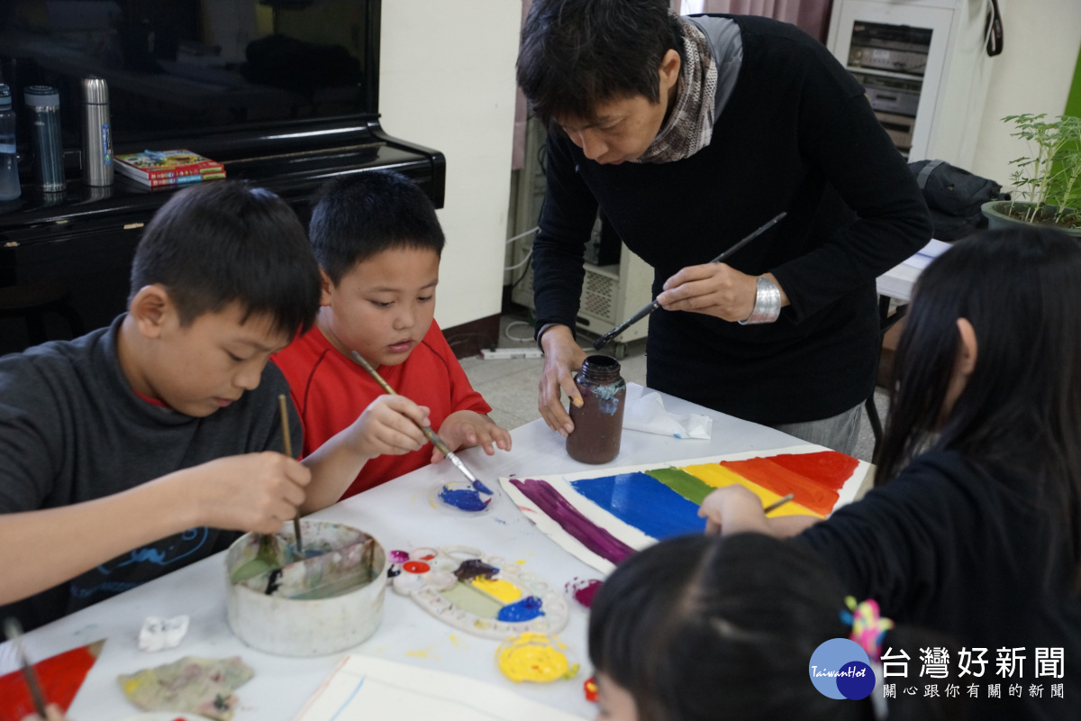 藝術家陳杏芬細心教導小朋及作友調色畫方式。
