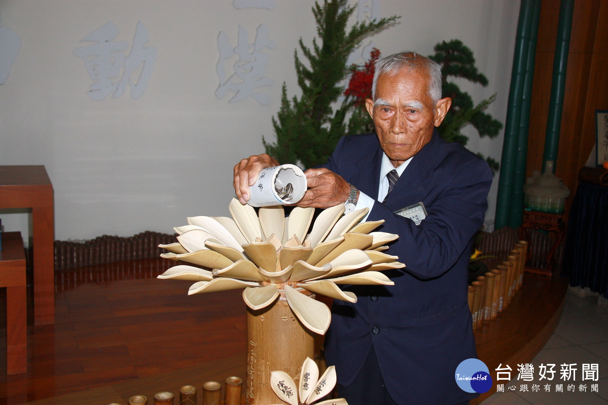 溫木增將竹筒內銅板注入功德海中。(記者扶小萍攝)