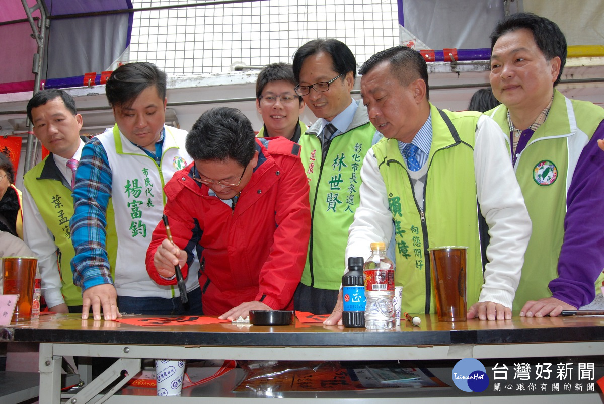 彰化市長邱建富在開化寺揮毫寫春聯送給民眾。