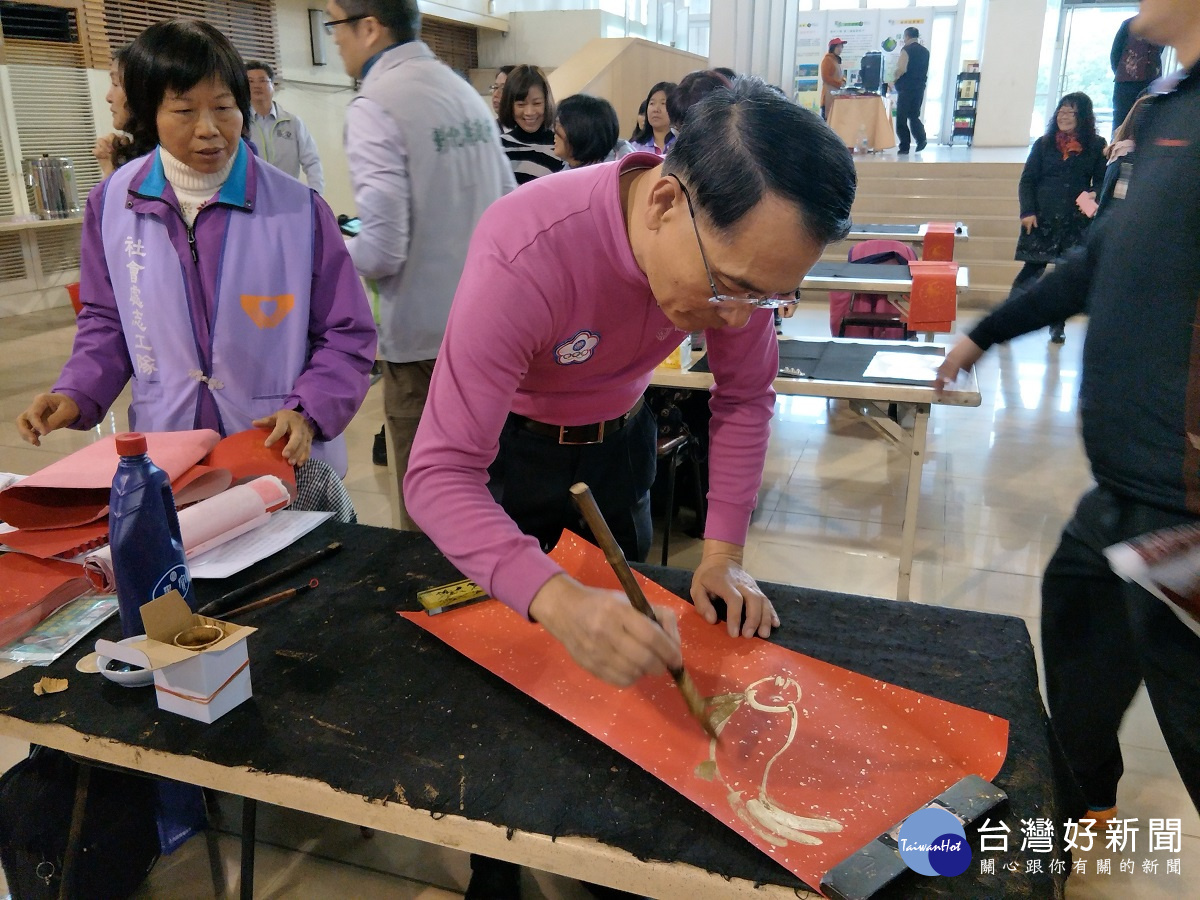 書法家方一成老師，現場揮毫畫春聯，吉祥喜氣，大批民眾排隊等候。圖／記者鄧富珍攝