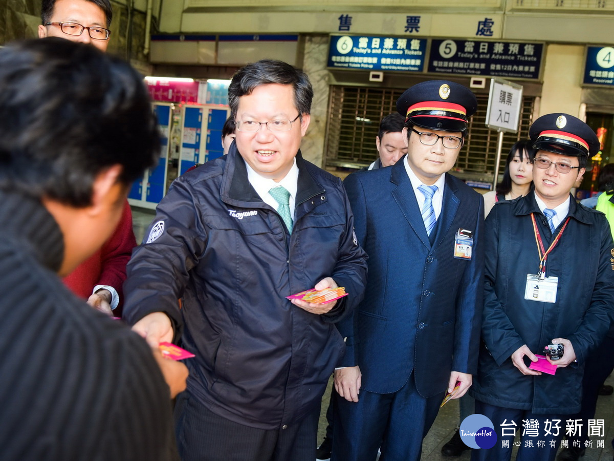 桃園市長鄭文燦到台鐵桃園站向旅客們祝福春節快樂,也致贈「桃喜雙全(犬)」福袋。