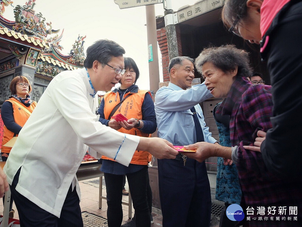 桃園市長鄭文燦在市府人員陪同中於三坑永福宮前發放「桃喜雙全(犬)」福袋給市民朋友。