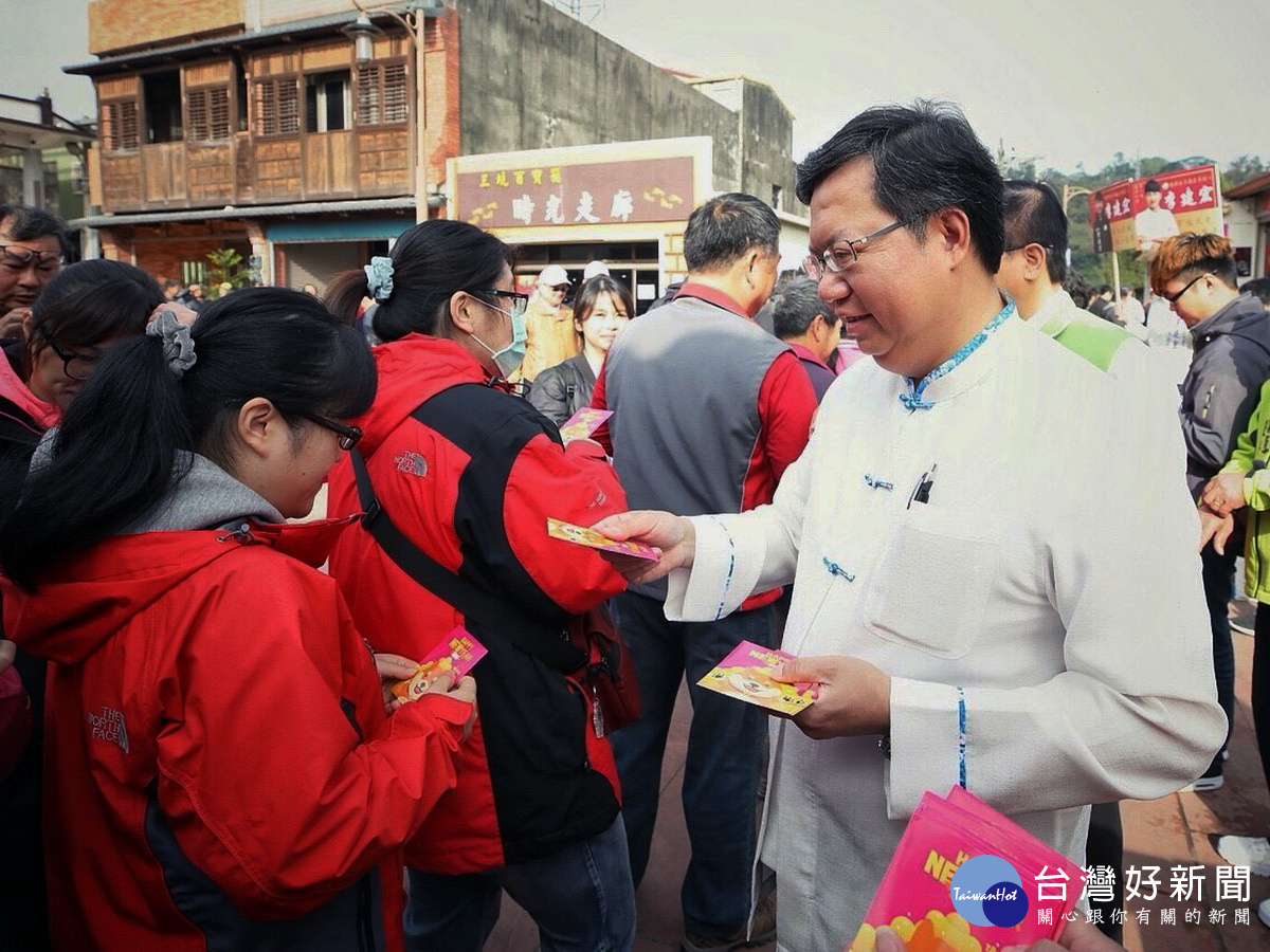 桃園市長鄭文燦在市府人員陪同中於三坑永福宮前發放「桃喜雙全（犬）」福袋給市民朋友。