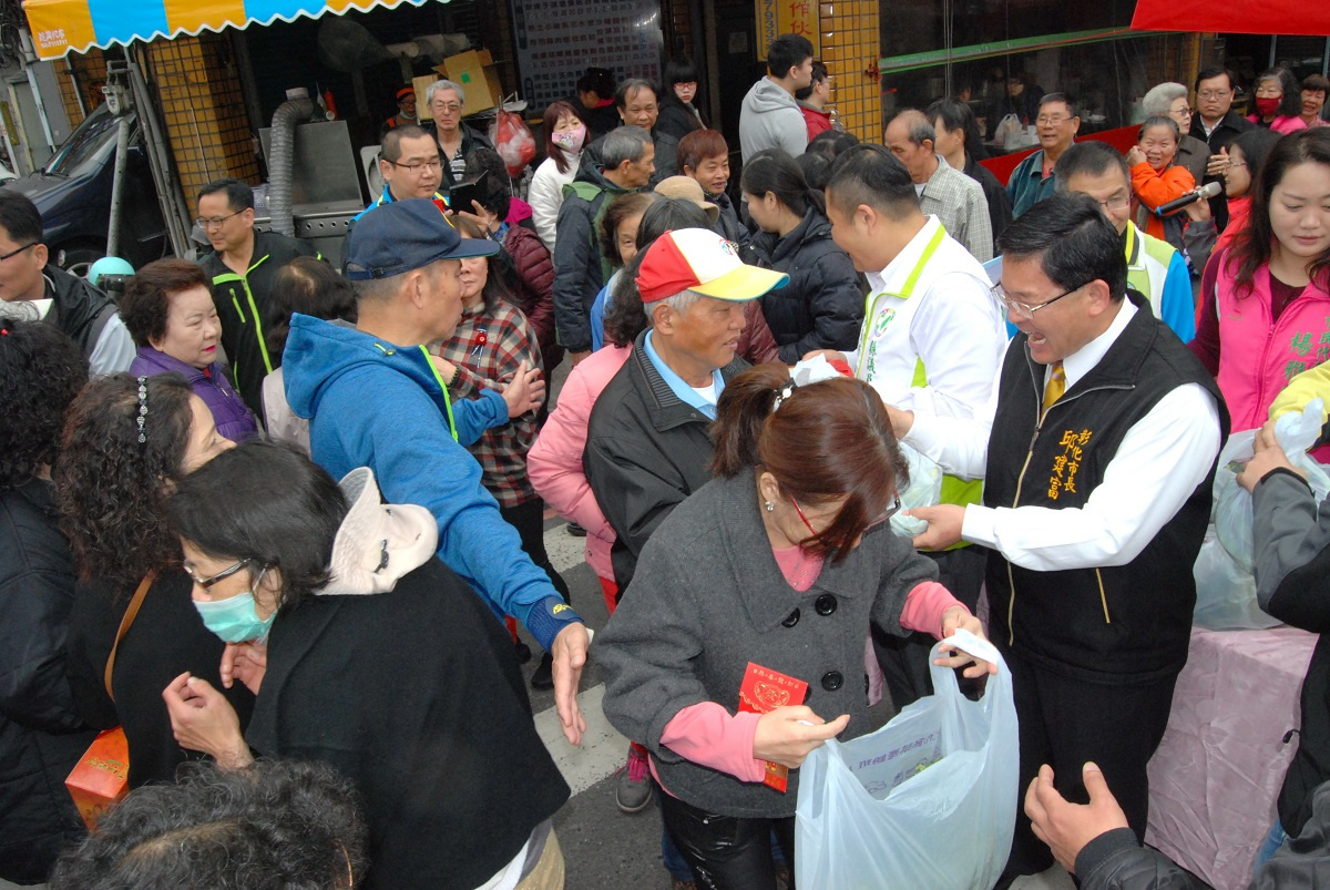 大批民眾一大早等著彰化市長邱建富發送青菜。