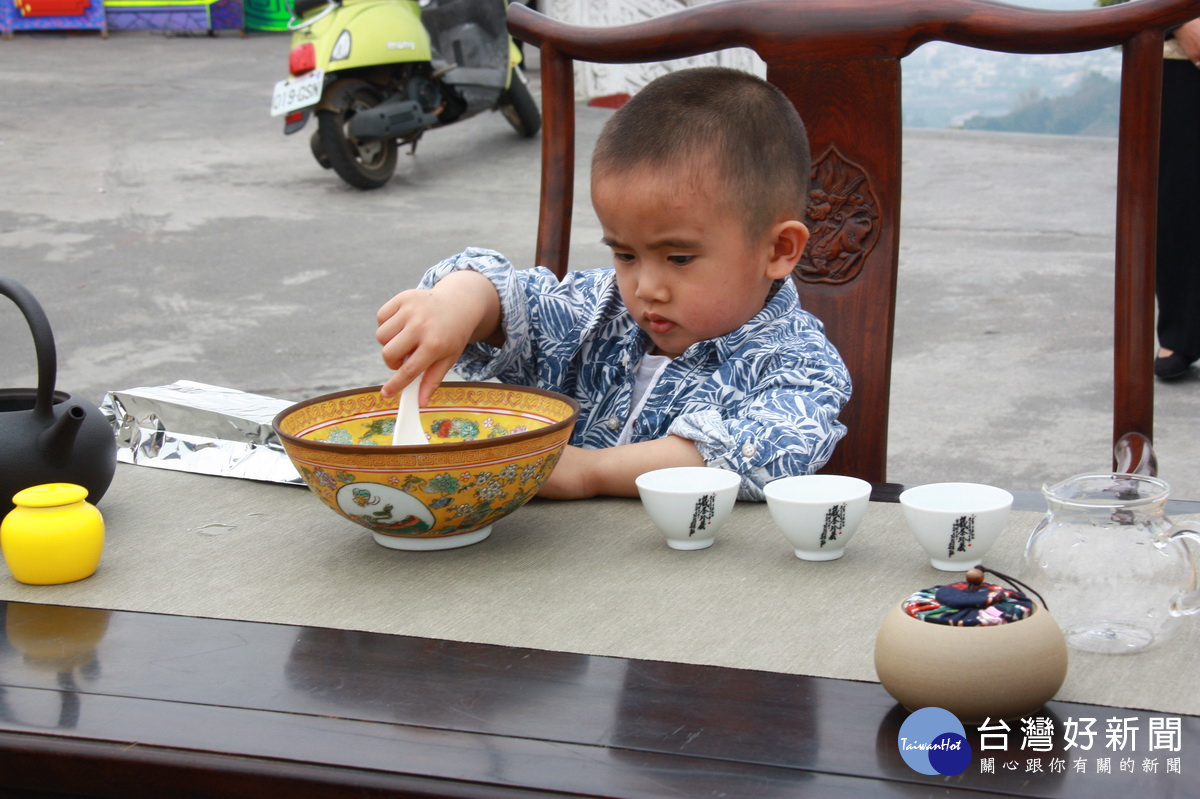 年僅3歲的謝宗哲以白茶敬獻帝爺公。（記者扶小萍攝）