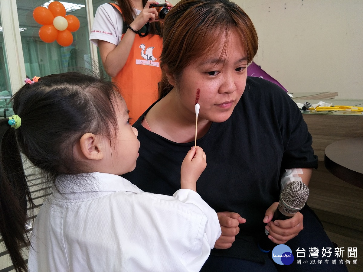 小朋友體驗醫護人員替病患擦藥。圖/記者鄧富珍攝