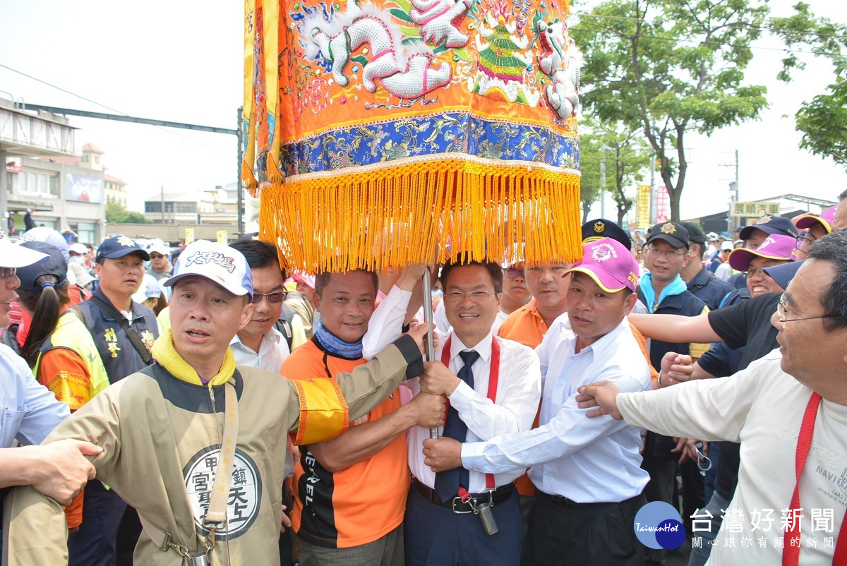 大甲媽祖遶境進香縣長魏明谷與游鄉長手持媽祖娘傘，接駕。