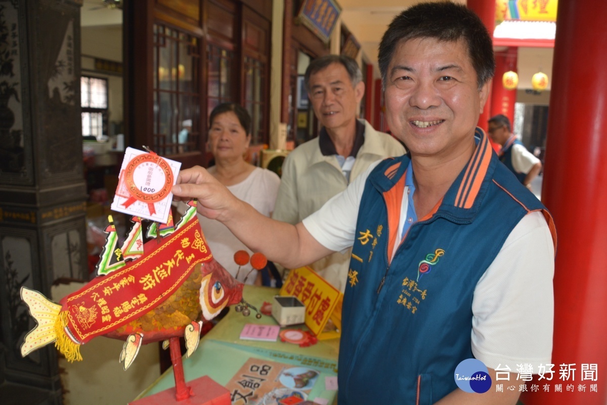 西港慶安宮總幹事方一峰親自為鯉魚神掛號第1000號的御前參謁證。(圖/記者黃芳祿攝)