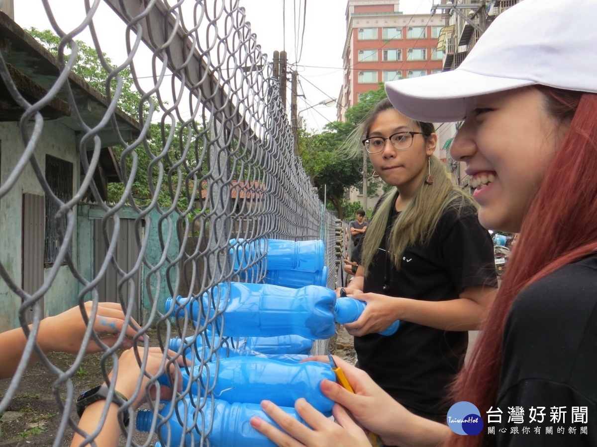 銘傳大學同學及社區居民,運用創意巧思與環保材料,一起動手為憲光二村周邊鐵絲網圍籬進行美化。
