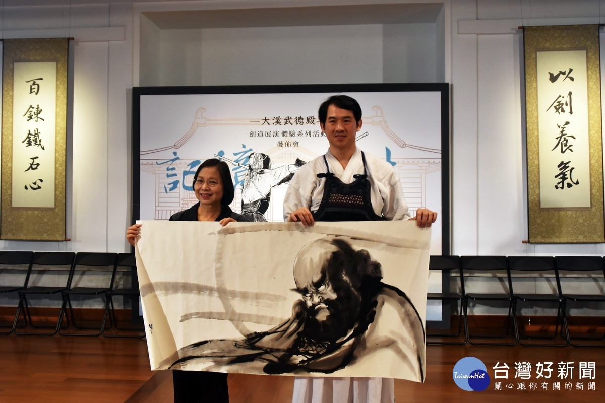 劍道畫家余勝芳老師現場揮毫創作達摩像與文化局長莊秀美合影留念。