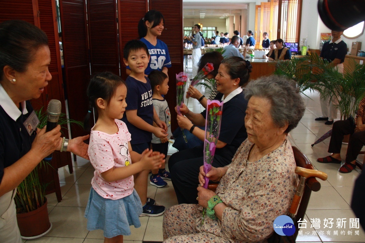 幼童向阿嬤獻上康乃馨並給予擁抱。（記者扶小萍攝）