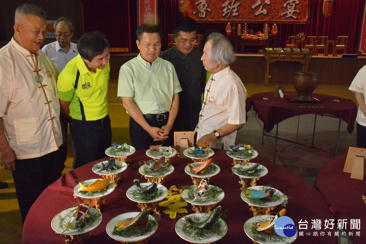 縣長魏明谷與文化局長陳文彬欣賞鹿港魯班公宴現場工藝作品。