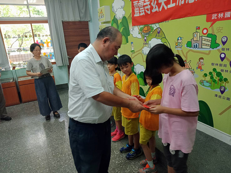 「靈雲寺玄天上帝慈善功德會」善行首航,住持蕭財元為清寒學童頒贈助學金學。(圖╱記者范文濱攝)