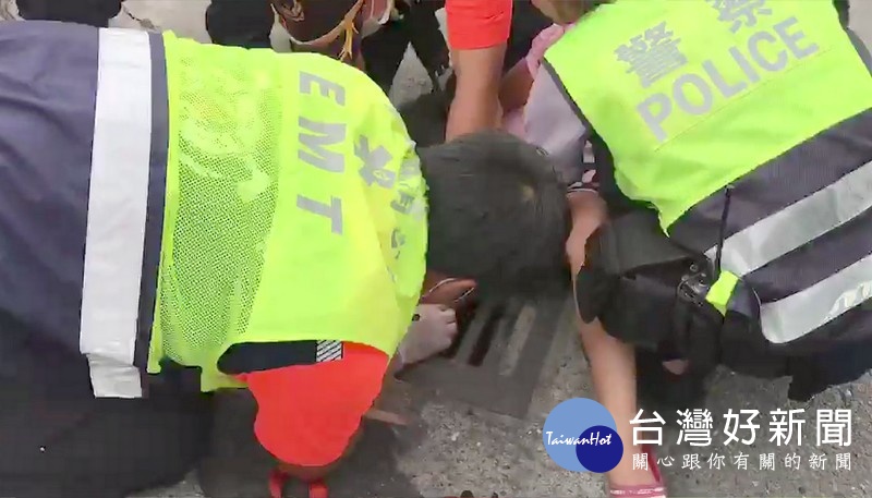 馬光所女警李采琳在消防救護人員破壞水溝蓋之際,將小朋友擁入懷中,減少恐懼感,如此體貼與細心的舉動深獲民眾讚許。(記者陳昭宗拍攝)