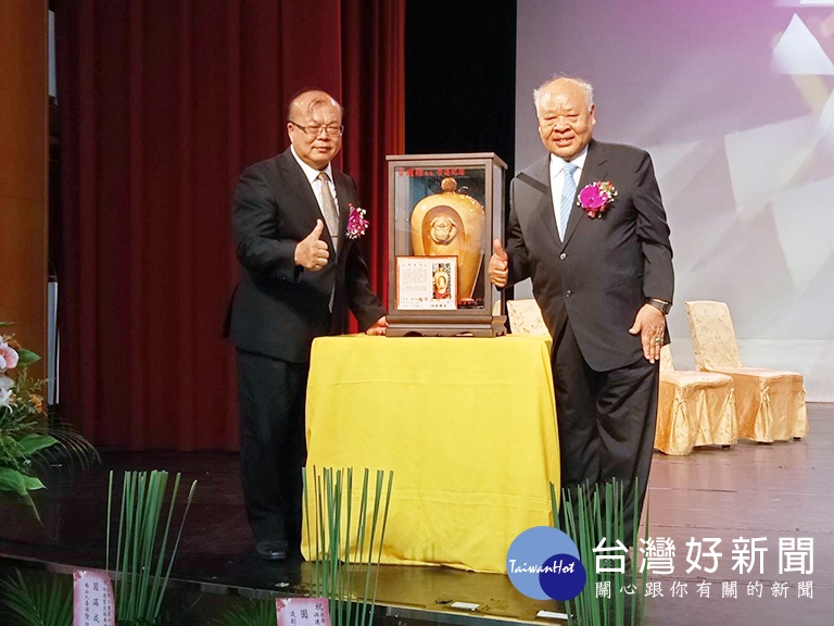 肯定與感謝黃耀祿校長40年的付出，董事長朱仁才（右者）特別致贈木雕紀念品。