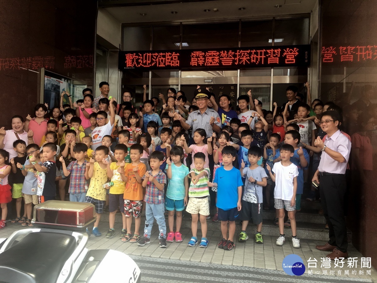 南投分局副分局長劉滉潾與學童合影。(記者扶小萍攝)
