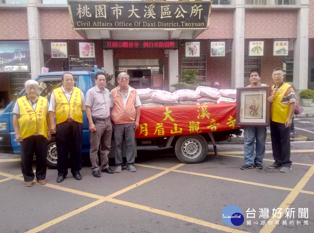 大溪月眉山觀音寺致贈白米給區公所,由區長黃睿松從李後田主委手中接下後轉交。