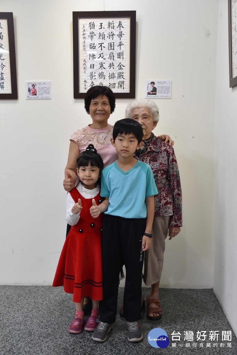 69歲的學員楊采華(左後)與93歲的母親、8歲的孫女,在自己的作品前留影。