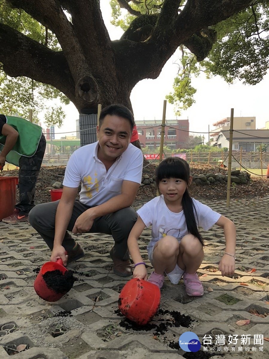 鎮長陳紀衡和小朋友一起為大樟樹公施肥。