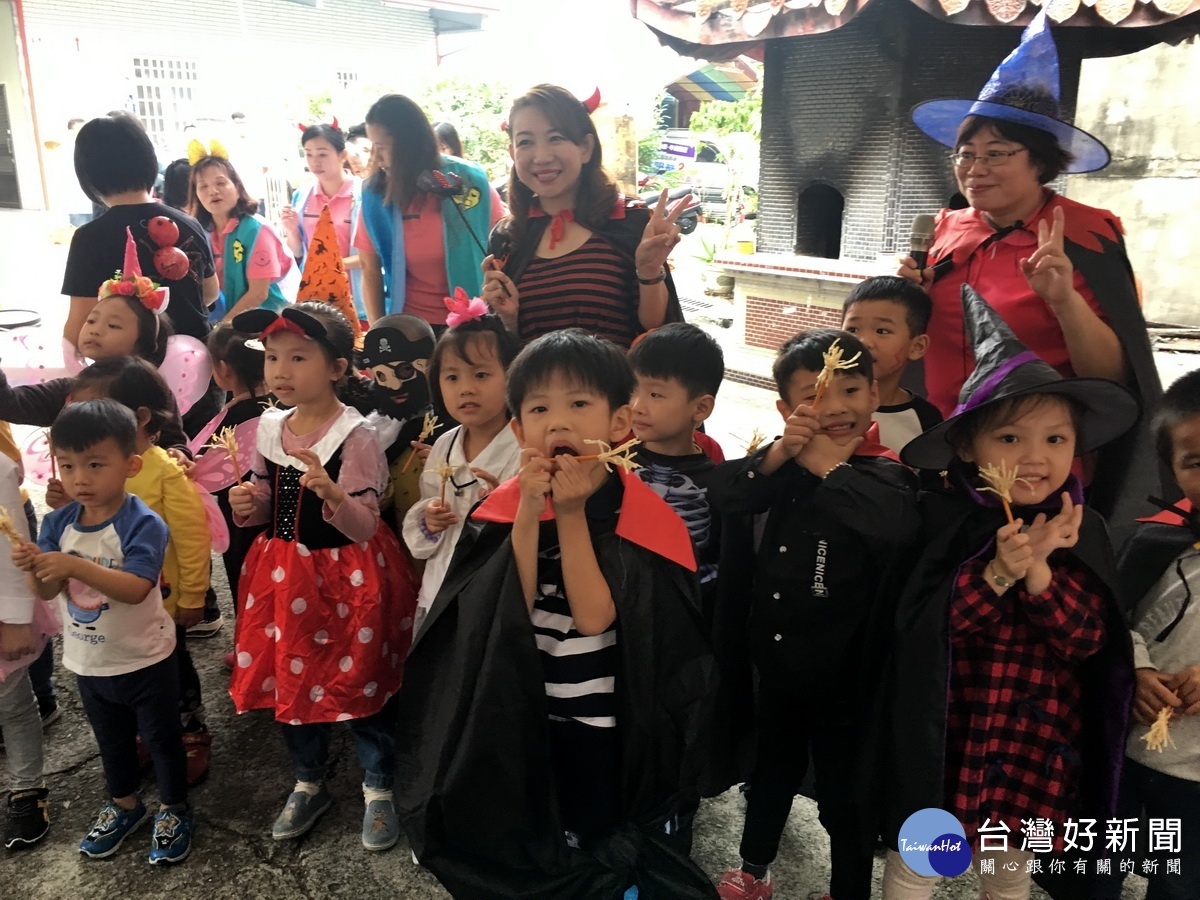 南瓜美魔女羅美玲和幼童展示可以吃的巫婆掃把。(記者扶小萍攝)