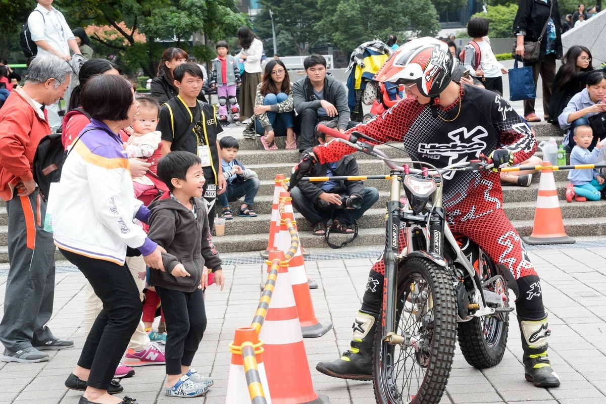 「2018桃園市機車嘉年華」中,特技機車車手與參觀的小朋友互動。