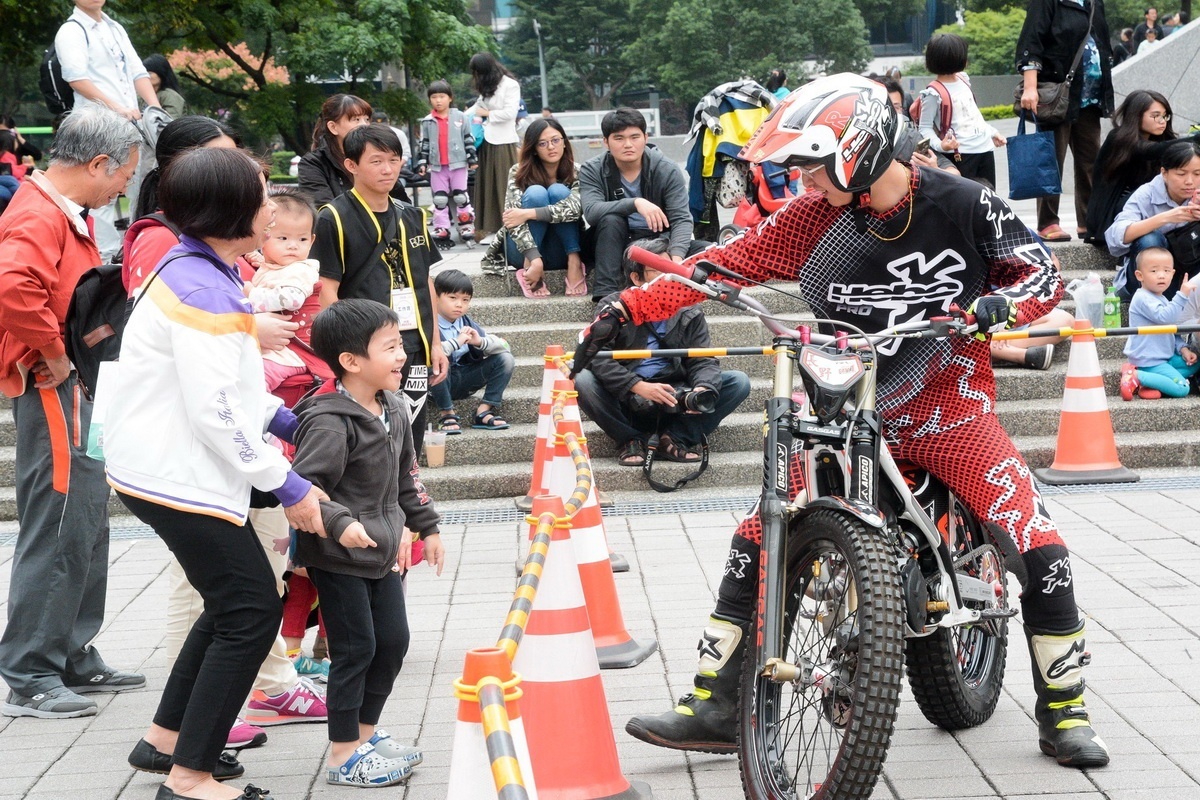 「2018桃園市機車嘉年華」中，特技機車車手與參觀的小朋友互動。