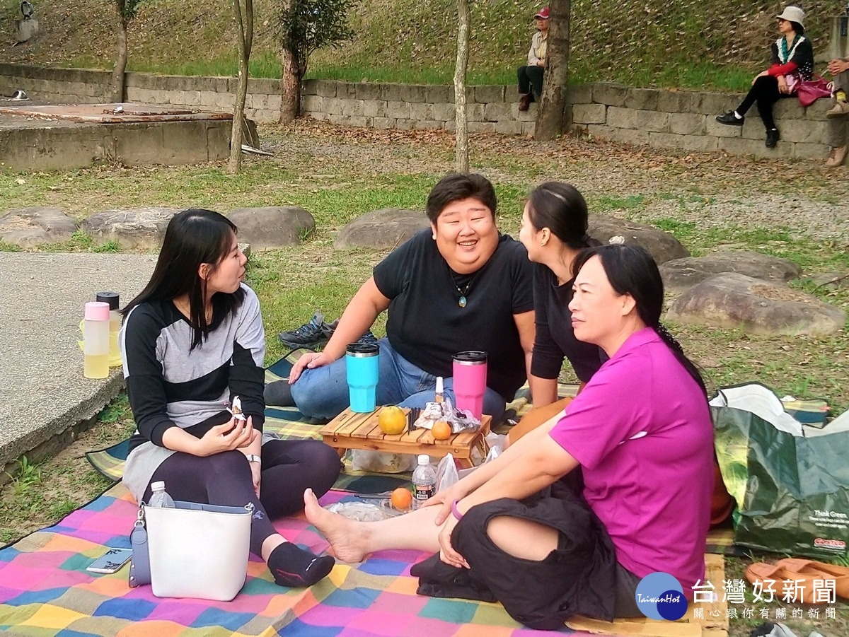 三五好友自備野餐墊而坐，一起聆聽悠揚樂曲，享受悠閒時光。〈記者吳素珍攝〉