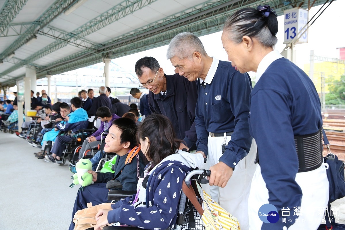 劉國良融入志工團體在彰化火車站，幫助和美仁愛實驗學校肢體障礙學生搭上火車。圖／慈濟基金會提供