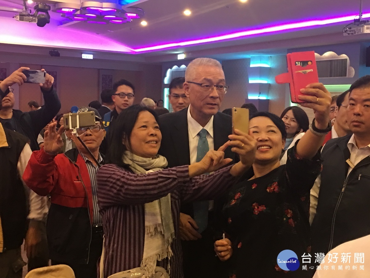 吳主席被黨員團團圍住要求合影。(記者扶小萍攝)