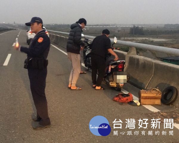 返鄉男大生因機車爆胎受困雲嘉大路,蔦松所員警巡邏發現,立即現場協助疏導交通,並聯繫機車行到場維修,為民服務順利排除障礙。(記者陳昭宗拍攝)